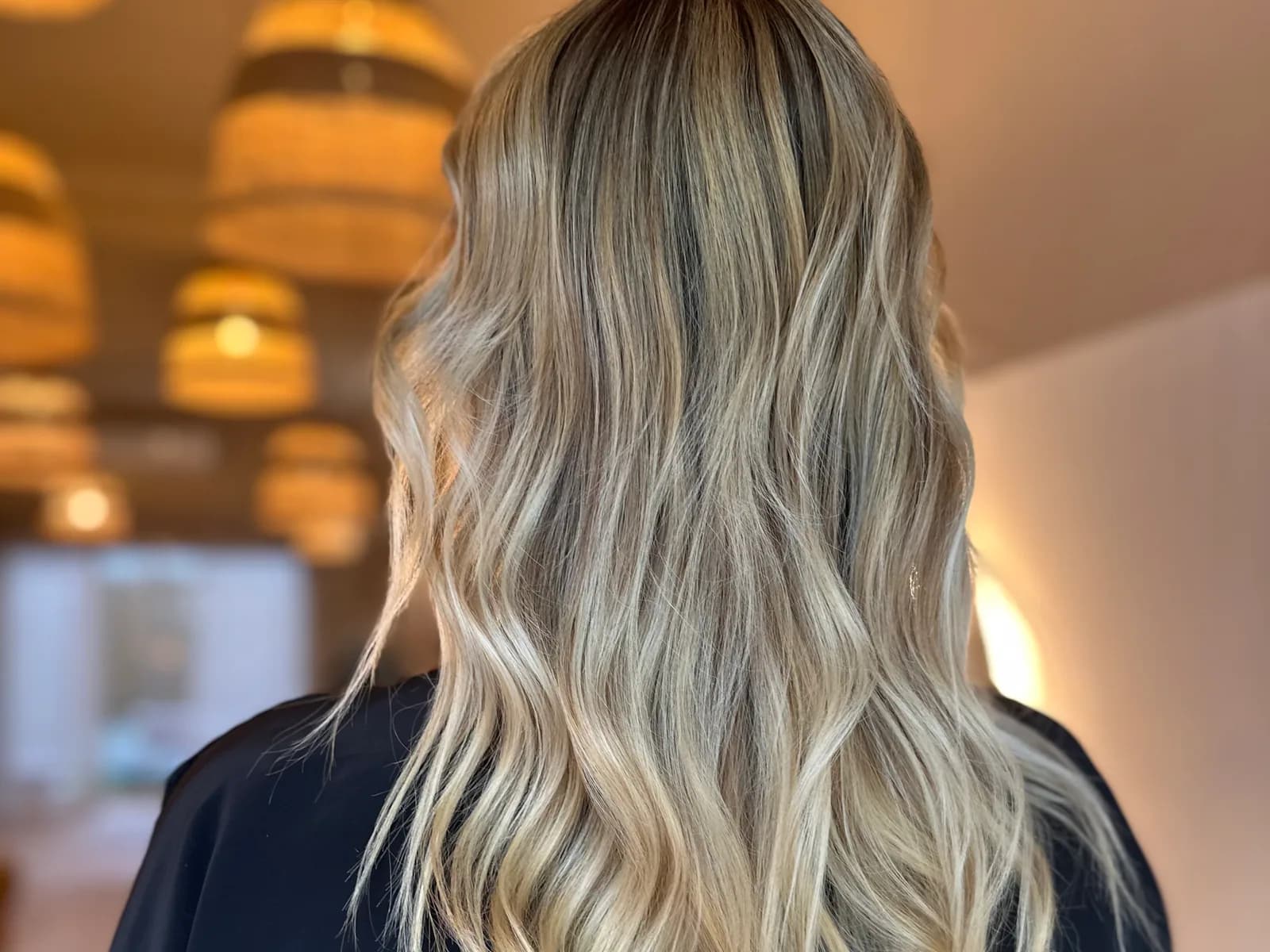 Vue de dos d’un blond californien ondulé réalisé chez Pure Beauté à Nice