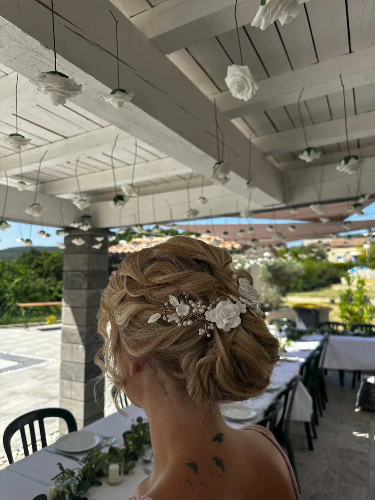 Vue de trois quarts d’un chignon de mariage tressé avec bijou de cheveux